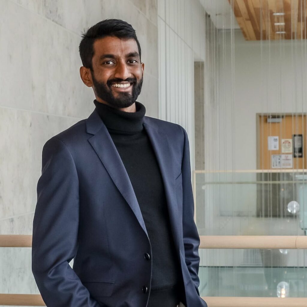Diverse young professional smiling in business casual attire at Youth Science Canada event on promoting youth science and innovation, indoor modern setting.