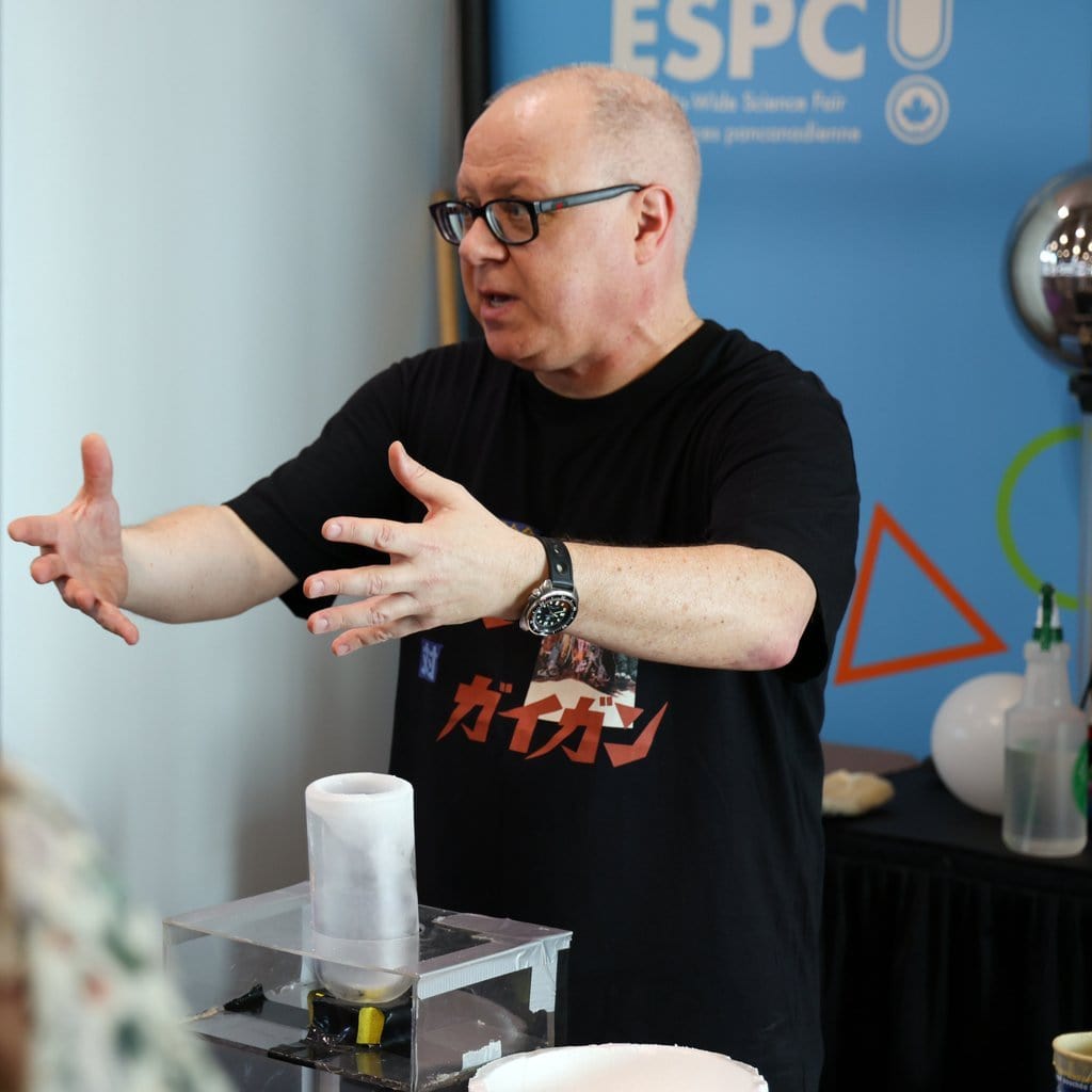 Science presenter explaining experiment at Youth Science Canada event