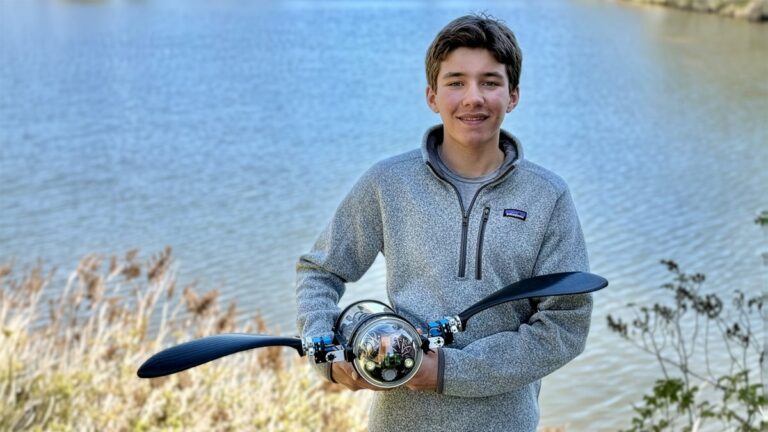 A young boy holding a science project with a mirror and tools by a lake, promoting youth science activities and outdoor STEM learning experiences.