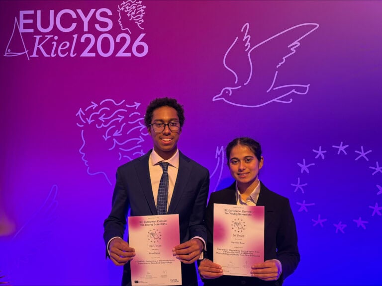 Two young students holding awards at EUCYS Kiel 2026, celebrating their success in the European Union Contest for Young Scientists.